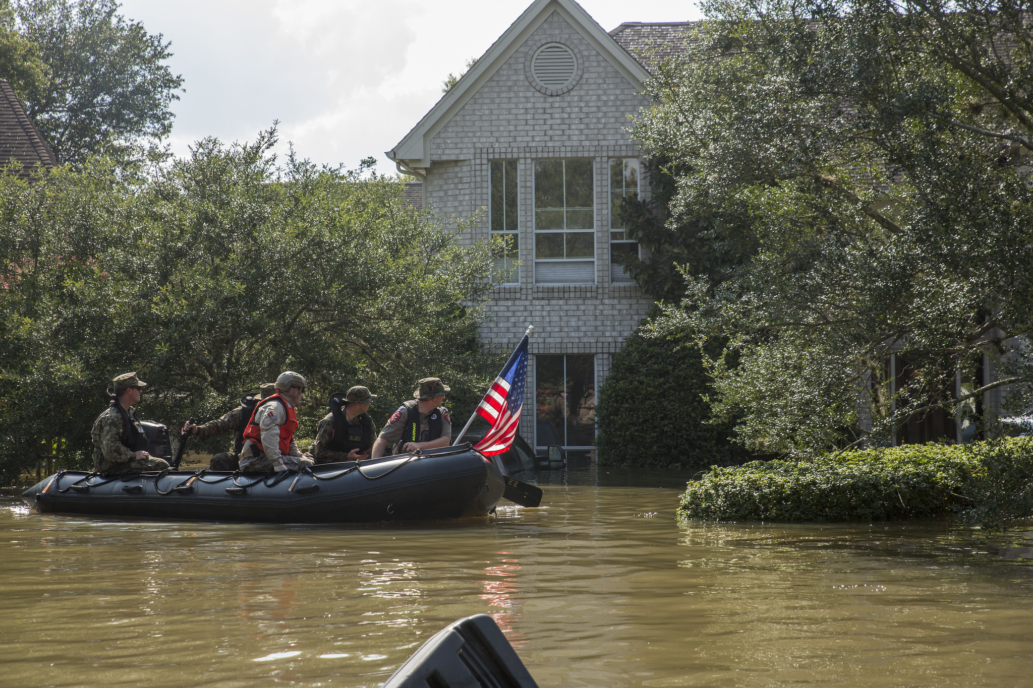 Marines with Charlie Company, 4th Reconnaissance Battalion, 4th Marine Division, Marine Forces Reserve, along with a member of the Texas Highway Patrol and Texas State Guard, patrol past a flooded house in Houston, Texas, Aug. 31, 2017. Hurricane Harvey landed Aug. 25, 2017, flooding thousands of homes and displaced over 30,000 people. (U.S. Marine Corps photo by Lance Cpl. Niles Lee/Released)