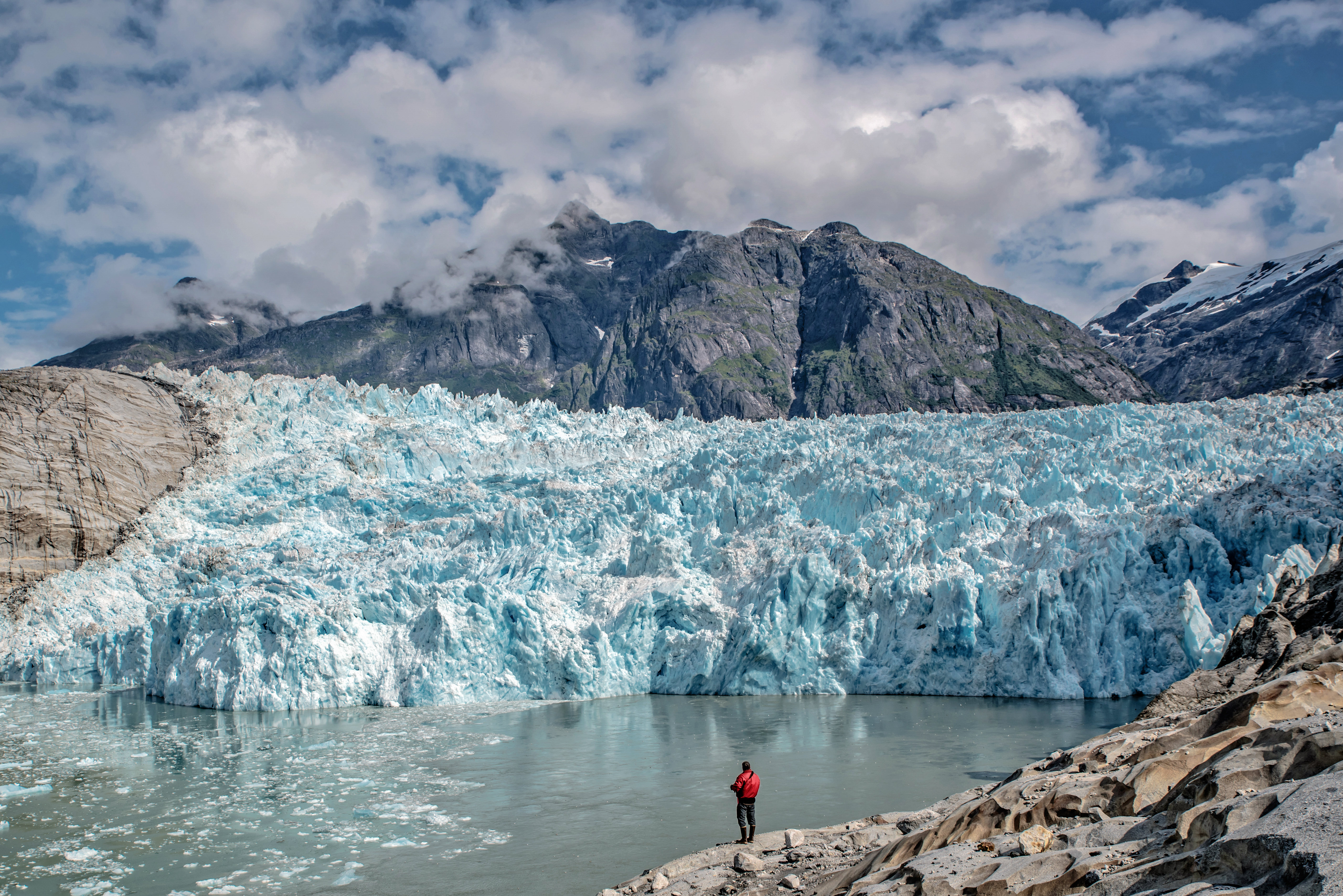An image of a glacier with a person standing in front of it.