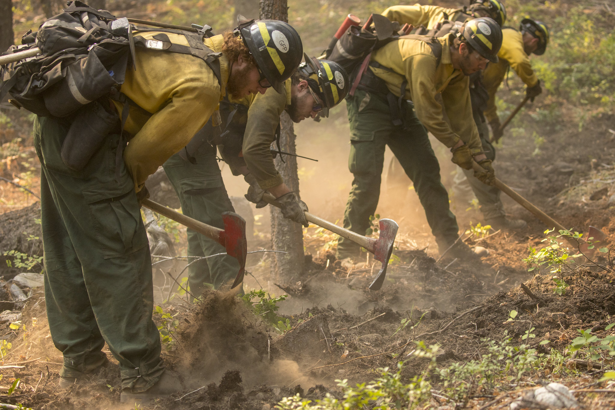 Firefighters dig line to prevent the spread of wildfire.