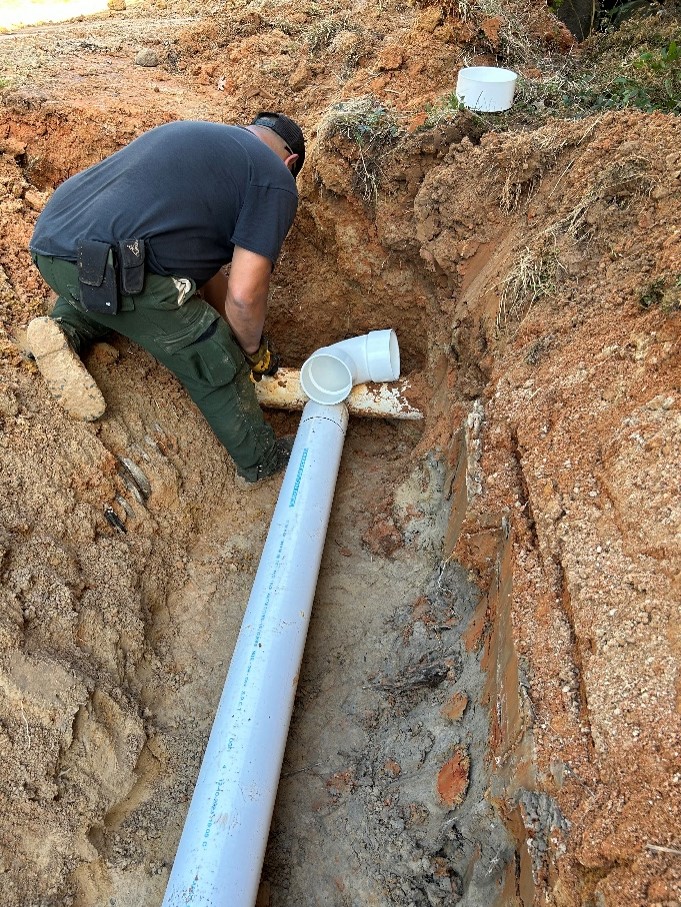 Pipe laying in trench to hook up water installation into 40,000 gal rainwater harvesting tank.