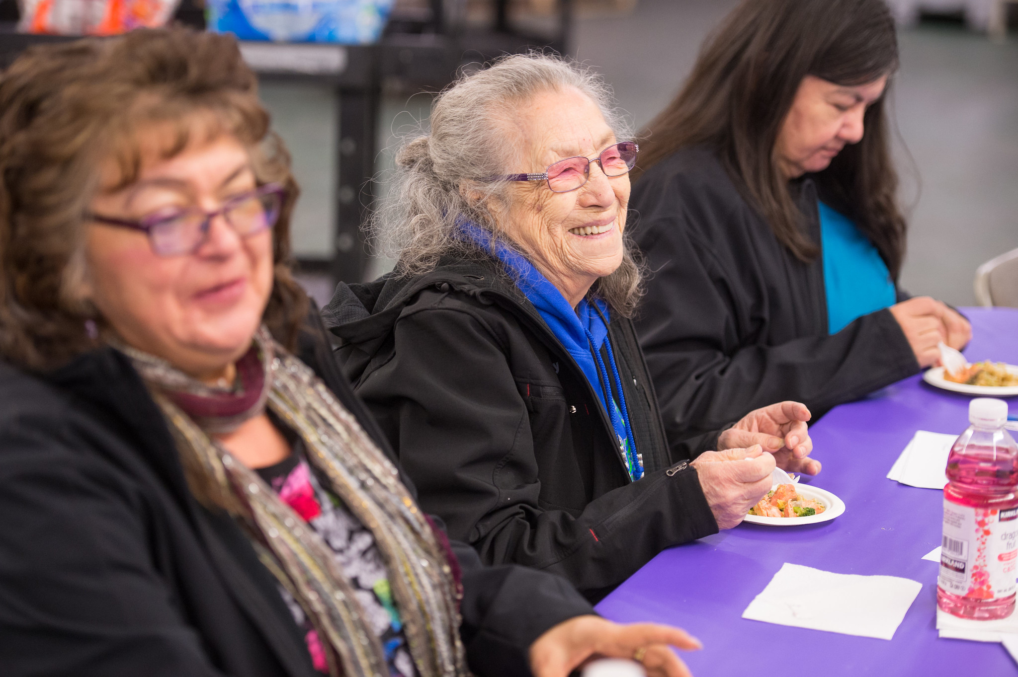 Three women from the Lummi Nation eat at a table.