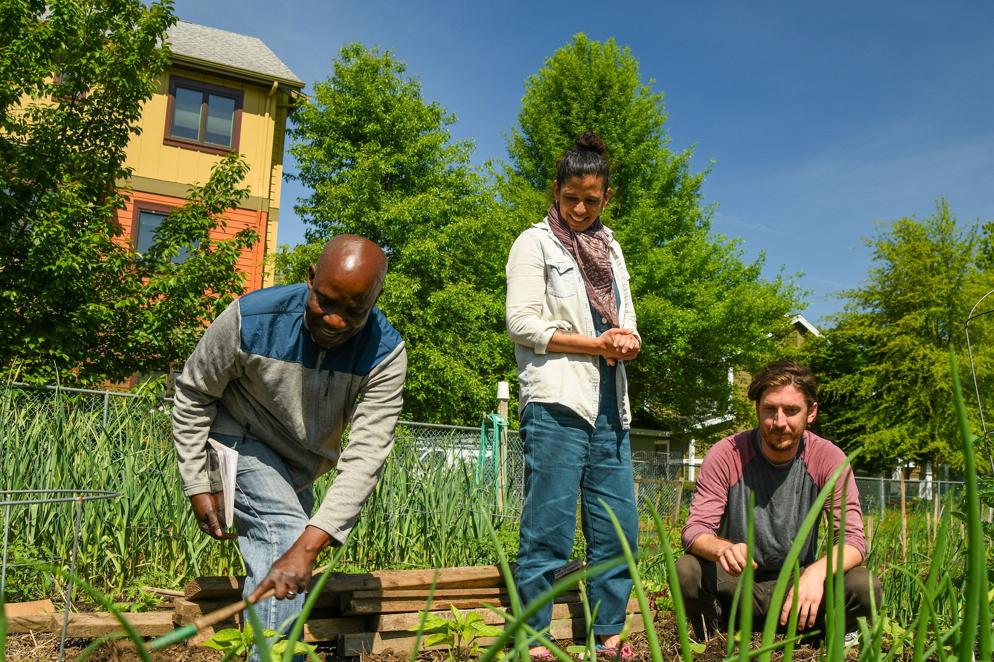 Three people tend a garden in Portland.