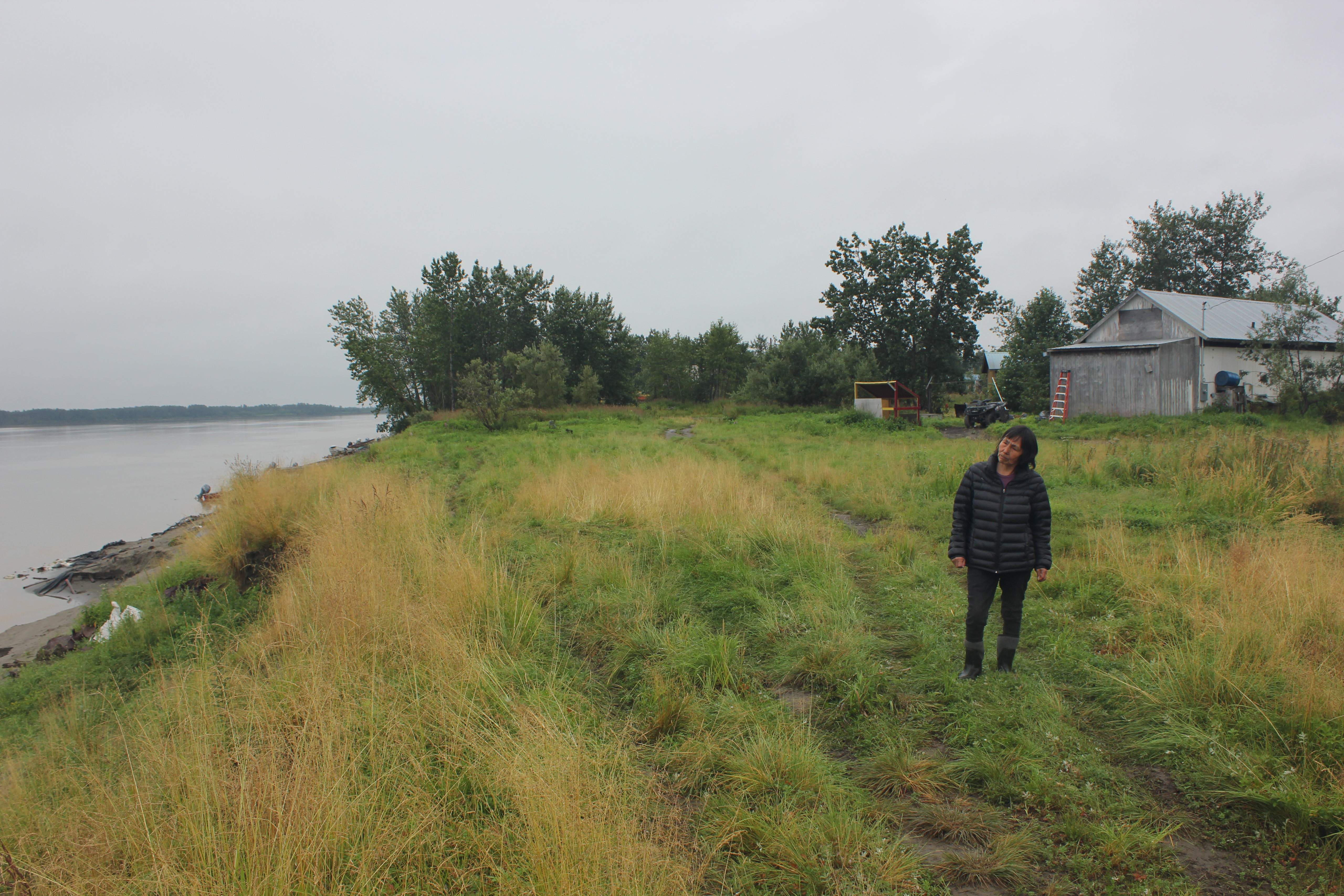 A woman stares out at the Kuskokwim River. 