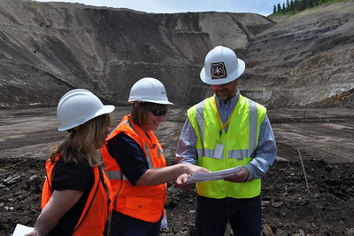 three people stand in a mine