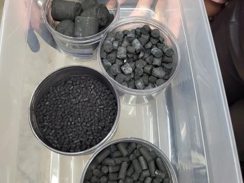four containers of different sizes of biochar